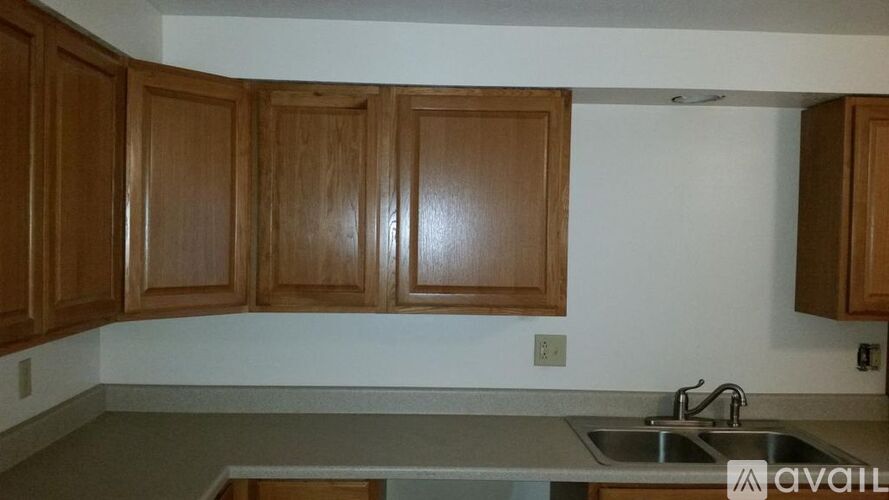 A kitchen with wooden cabinets and a stainless steel sink.