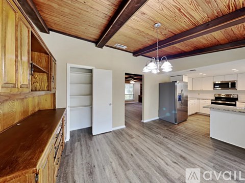 A modern kitchen with wooden cabinets and a refrigerator.