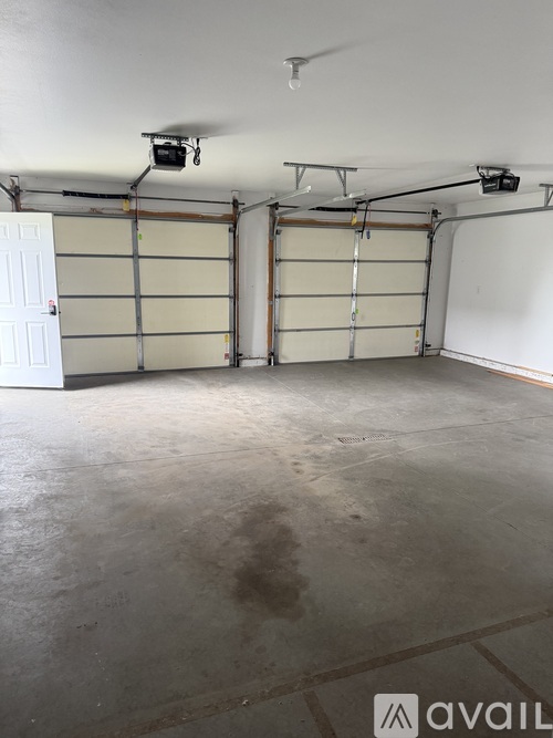 A spacious garage with a white door and a ceiling fan.