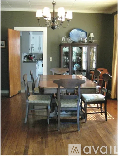 A dining room with a wooden table and chairs.