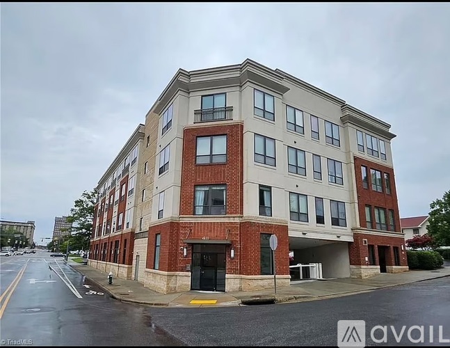 A multi-story building with a mix of brick and siding exterior.