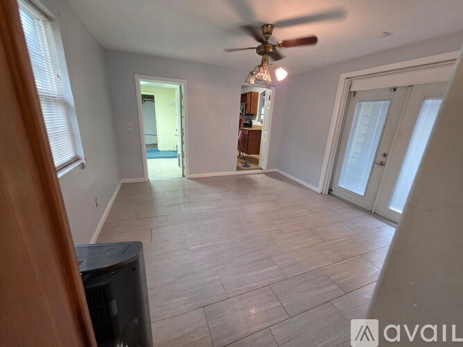 A living room with a ceiling fan and a television.