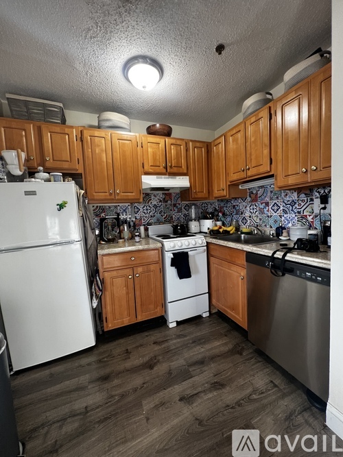 A kitchen with wooden cabinets and a white refrigerator.