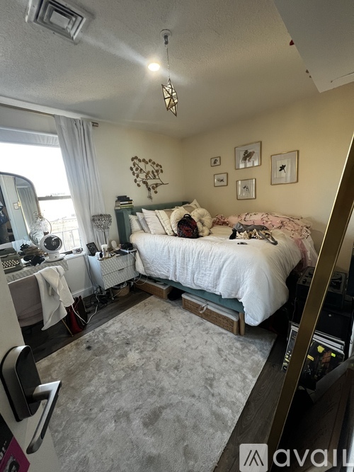 A bedroom with a bed, desk, and chair.
