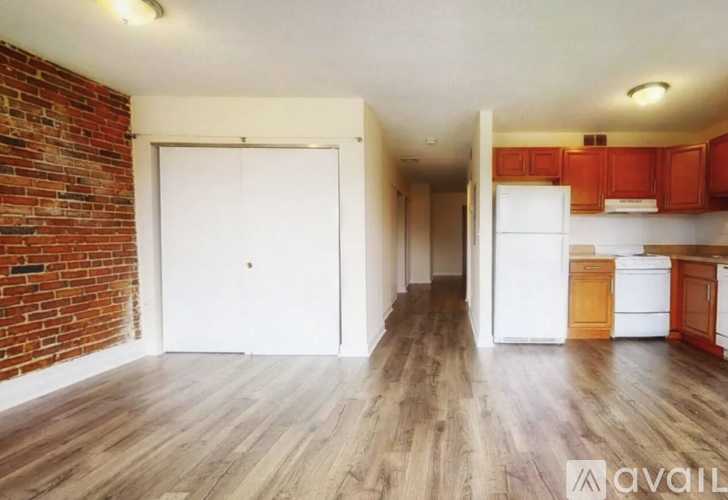 A room with a brick wall and wooden flooring.