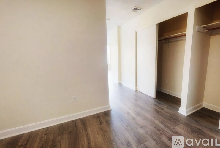 A room with wooden flooring and white walls.
