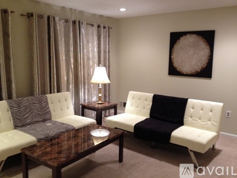 A living room with a white couch and a brown coffee table.