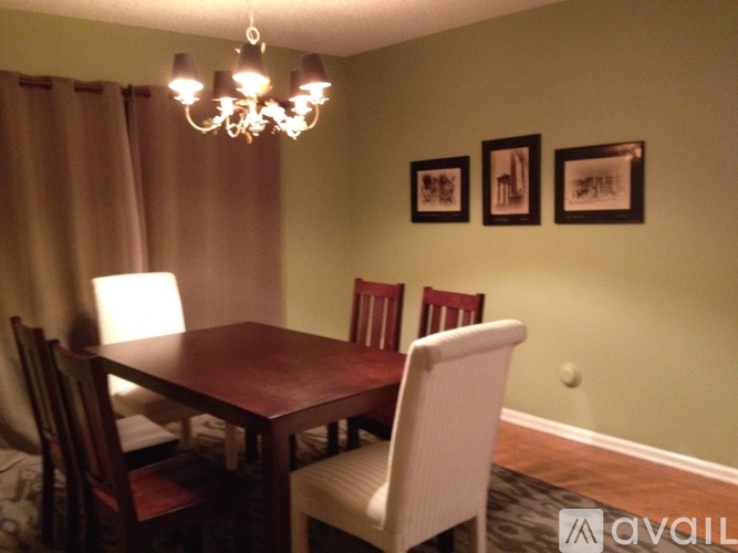 A dining room with a wooden table and chairs.