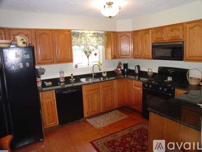 A kitchen with wooden cabinets and black appliances.