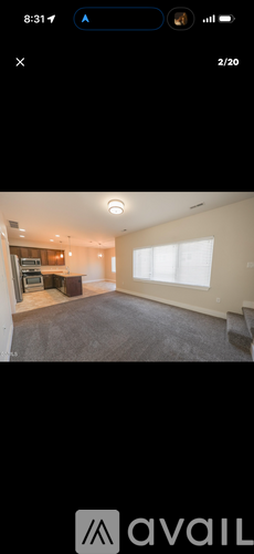 A room with a large window and a grey carpet.