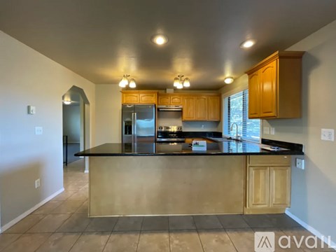 A kitchen with wooden cabinets and a black countertop.