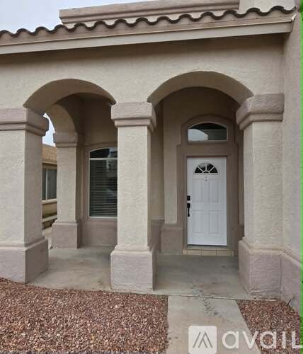 A house with a white door and two arches on either side.