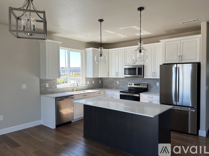A modern kitchen with a large island and stainless steel appliances.