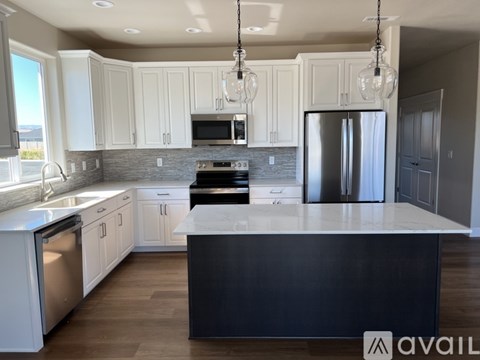 A modern kitchen with white cabinets and a black island.