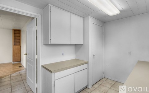 A kitchen area with white cabinets and a countertop.