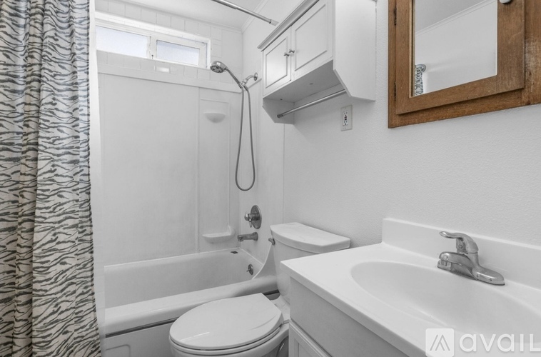 A bathroom with a white toilet, a white sink, and a white bathtub.