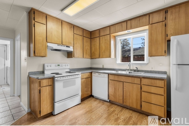 A kitchen with wooden cabinets and white appliances.