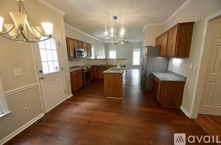A kitchen with wooden floors and cabinets.