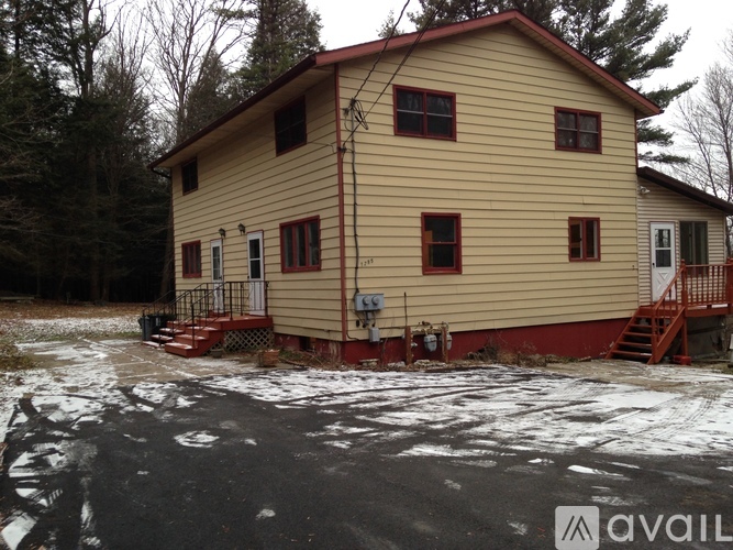 A house with a red roof and a porch with stairs.