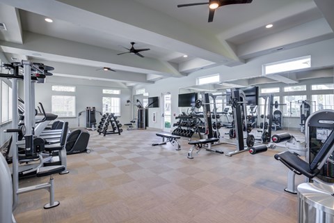 A spacious gym with a variety of equipment and a checkered floor.