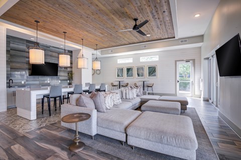 A modern living room with a grey sofa and a wooden ceiling.