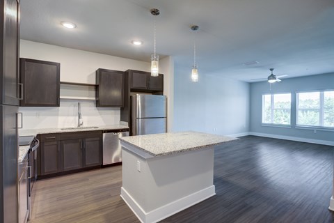 A kitchen with dark brown cabinets and a white island.