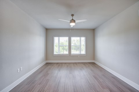 A room with a ceiling fan and a window.
