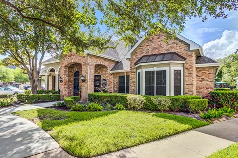 A house with a brick facade and a large front yard.