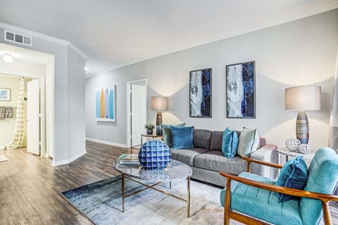 A living room with a grey couch and a blue chair.