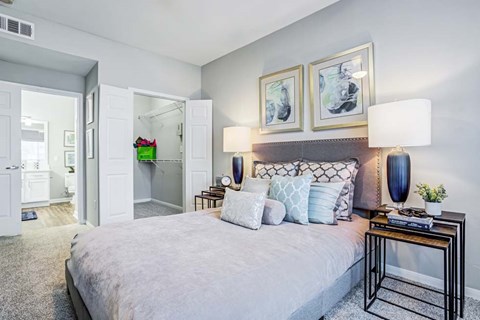 A bedroom with a large bed and a black metal side table.