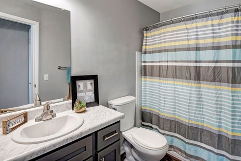 A bathroom with a white sink and a toilet.
