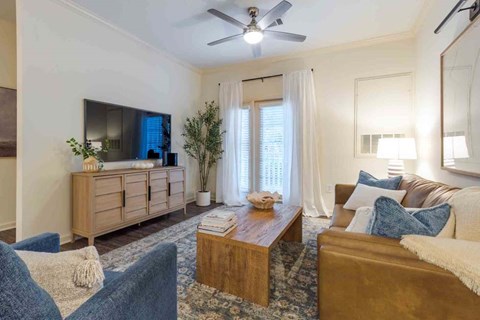 A living room with a blue couch, a wooden coffee table, and a flat screen TV.