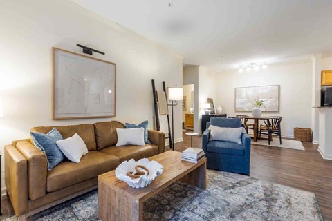 A living room with a brown leather couch and a coffee table in the center.