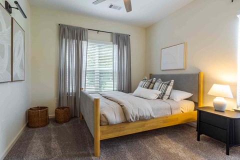 A bedroom with a large bed and a ceiling fan.