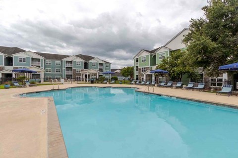 A large swimming pool in front of apartment buildings.