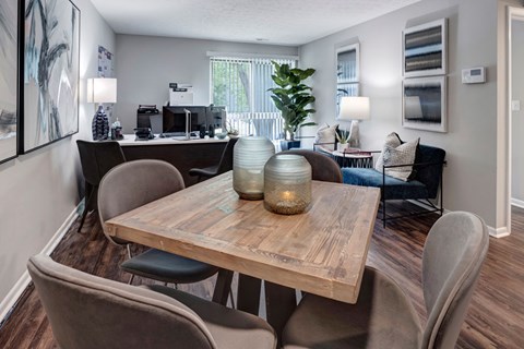 A modern dining room with a wooden table and grey chairs.