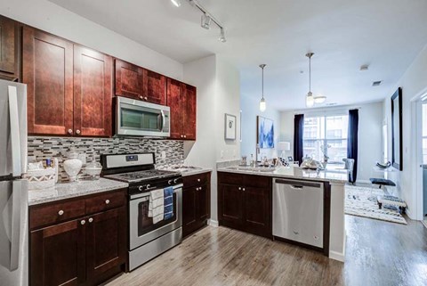 A kitchen with dark wood cabinets and stainless steel appliances.