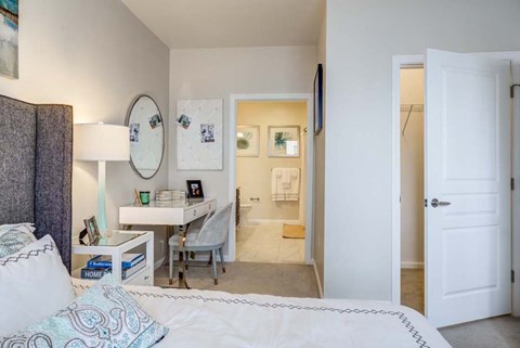 A bedroom with a bed, desk, and chair.
