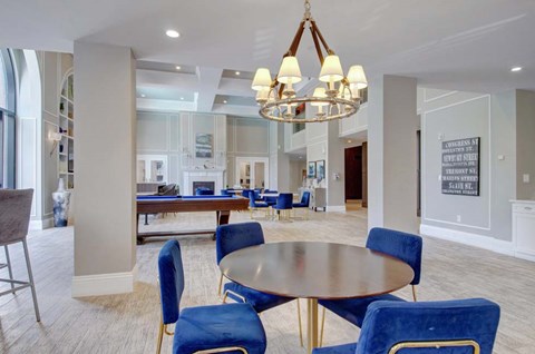 A dining room with a round table and blue chairs.