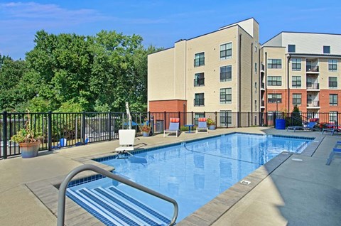 A swimming pool in front of a multi-story apartment building.