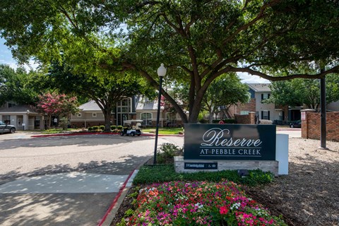 A sign that says Reserve at Pebble Creek in front of a building.