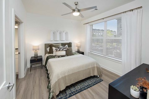 A bedroom with a large bed and a ceiling fan.