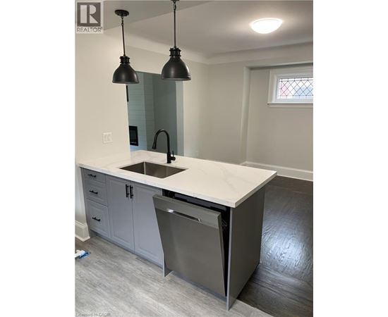 A kitchen with a white counter top and a dishwasher.