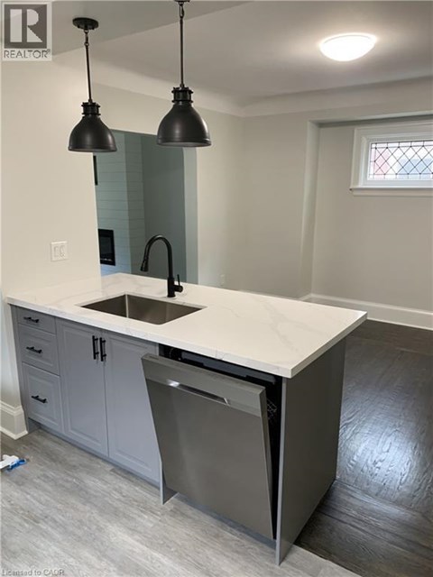 A kitchen with a white counter top and a dishwasher.