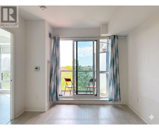 A room with a sliding glass door leading to a balcony with a chair and a table.