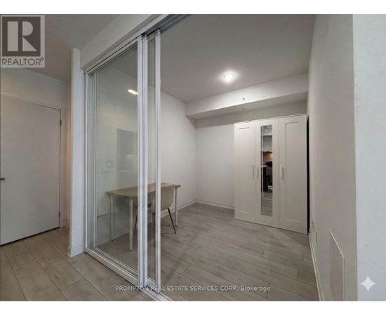 A room with a glass door and a wooden floor.