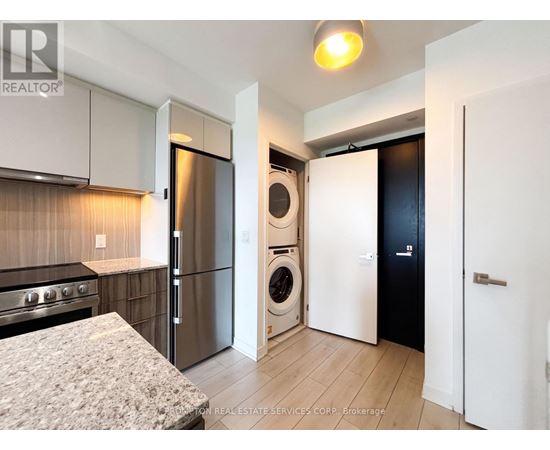 A kitchen with a stove top oven and a refrigerator.