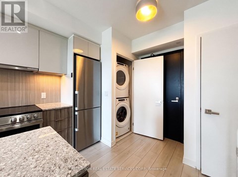 A kitchen with a stove top oven and a refrigerator.