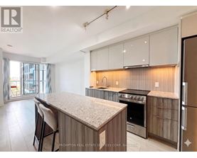 A kitchen with a granite countertop and stainless steel appliances.