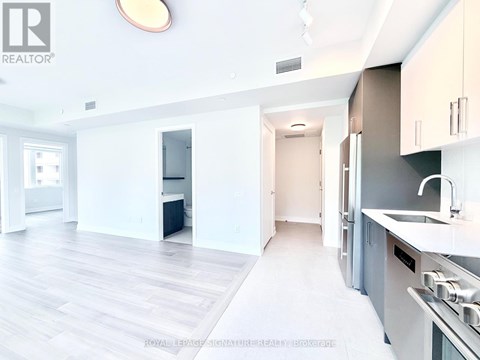 A modern kitchen with white cabinets and a stainless steel refrigerator.